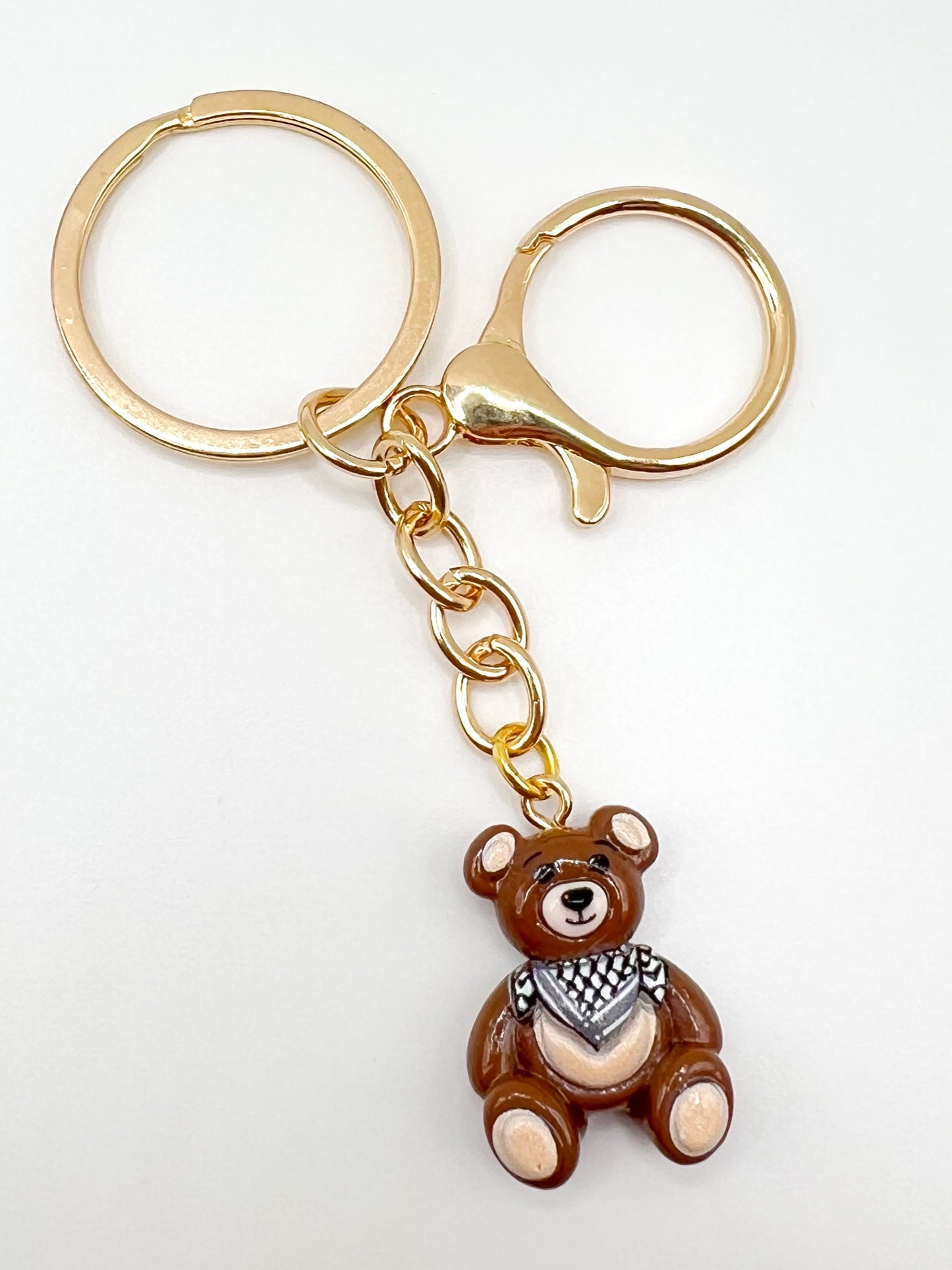 Keychain with a keffiyeh teddy bear charm on a white background