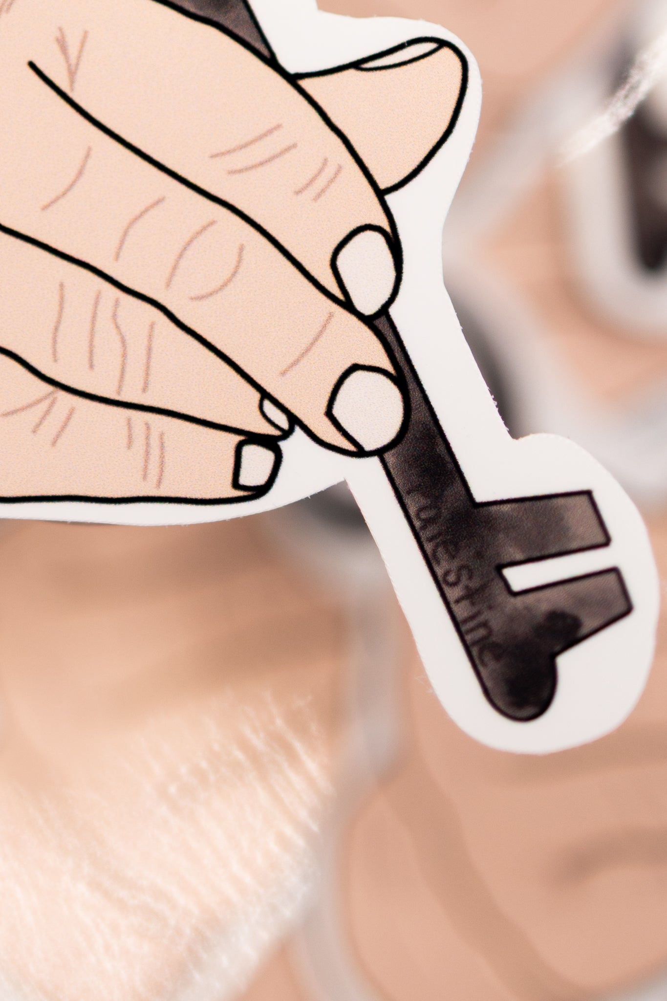 Sticker of a hand holding a key of return