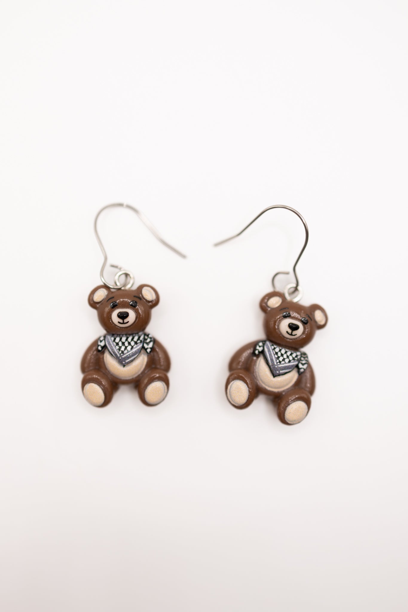 Pair of teddy bear-shaped earrings with keffiyeh on a white background