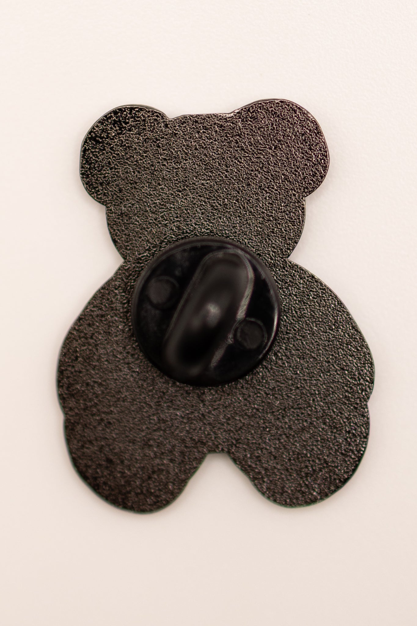 Black teddy bear-shaped object on a white background