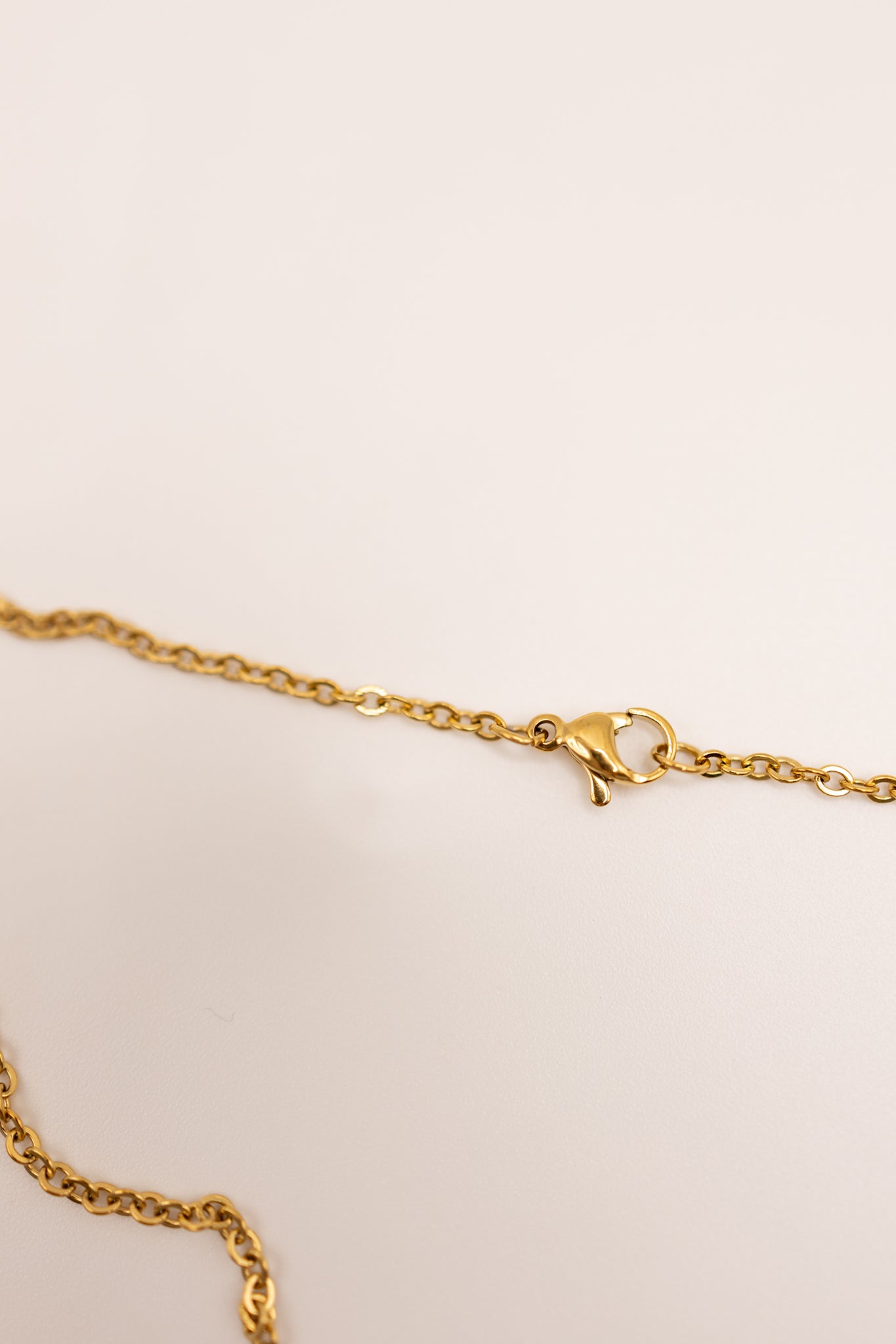 Gold necklace on a beige background