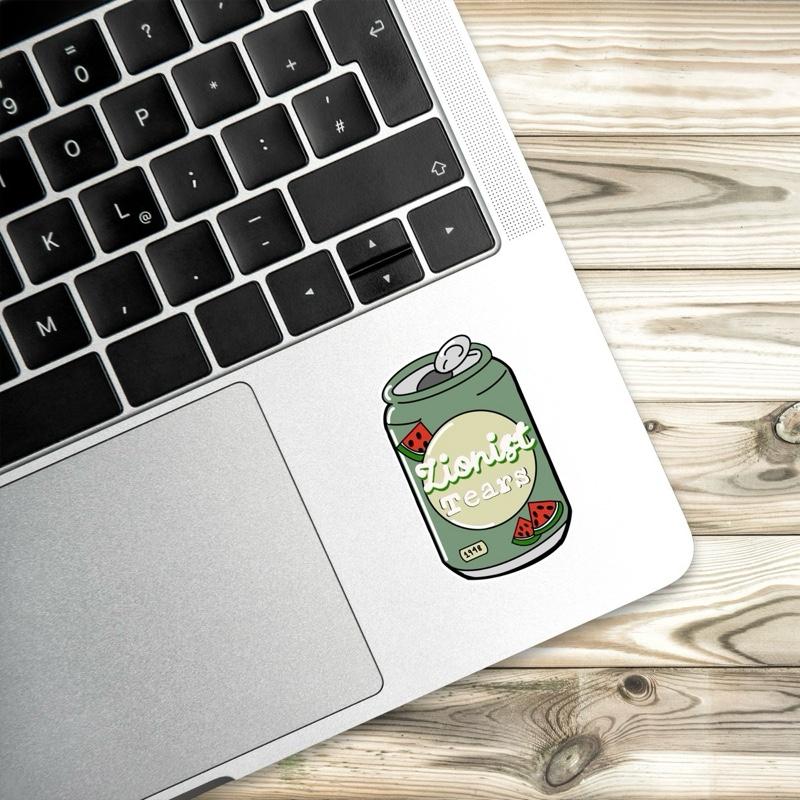 Laptop with a 'Zionist Tears' sticker on a wooden surface