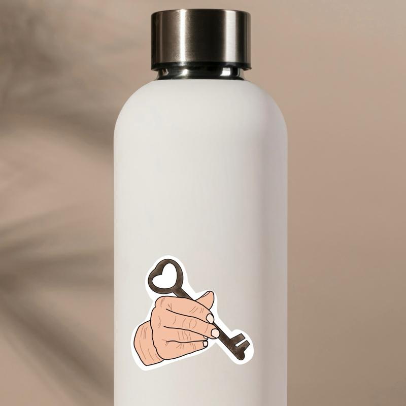 White water bottle with a key and hand design on a beige background