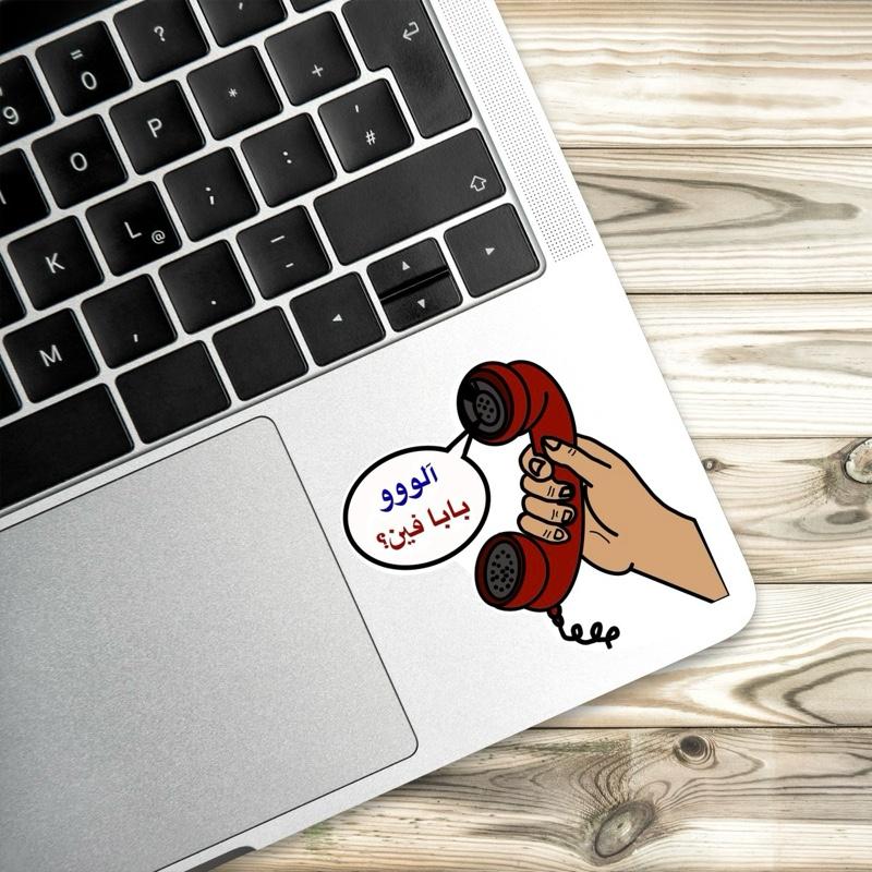 Laptop with a cartoon hand holding a red phone receiver on a wooden surface