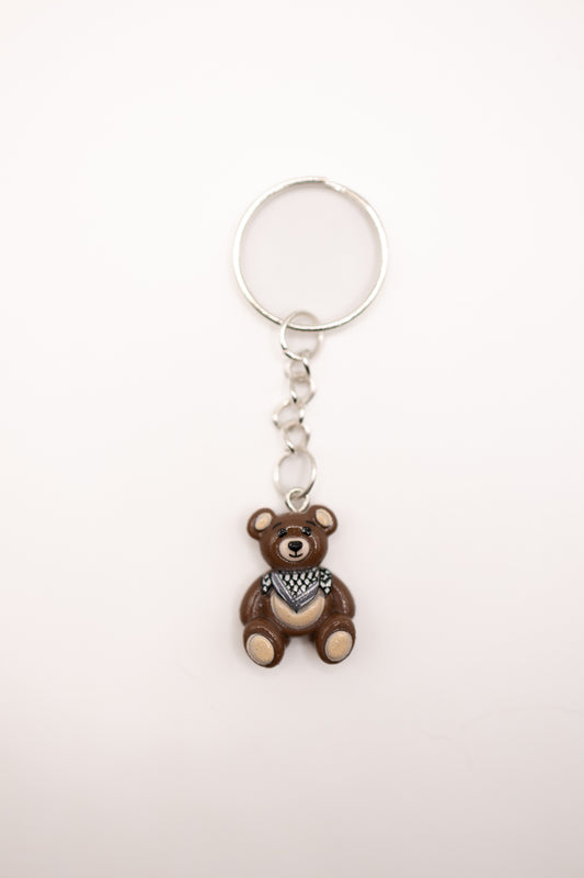 Keychain with a bear charm and keffiyeh scarf on a white background