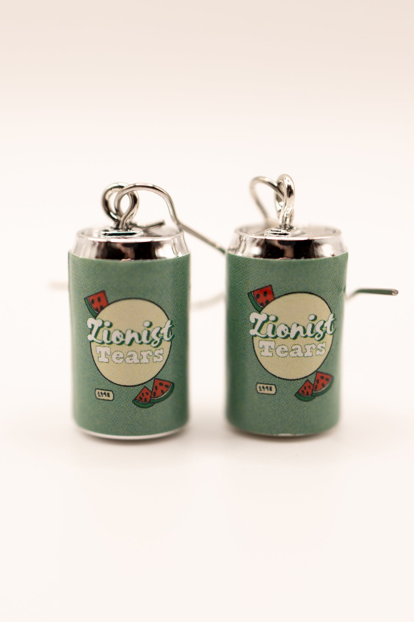 Earrings resembling a can with 'Third Cultr Kid' branding 