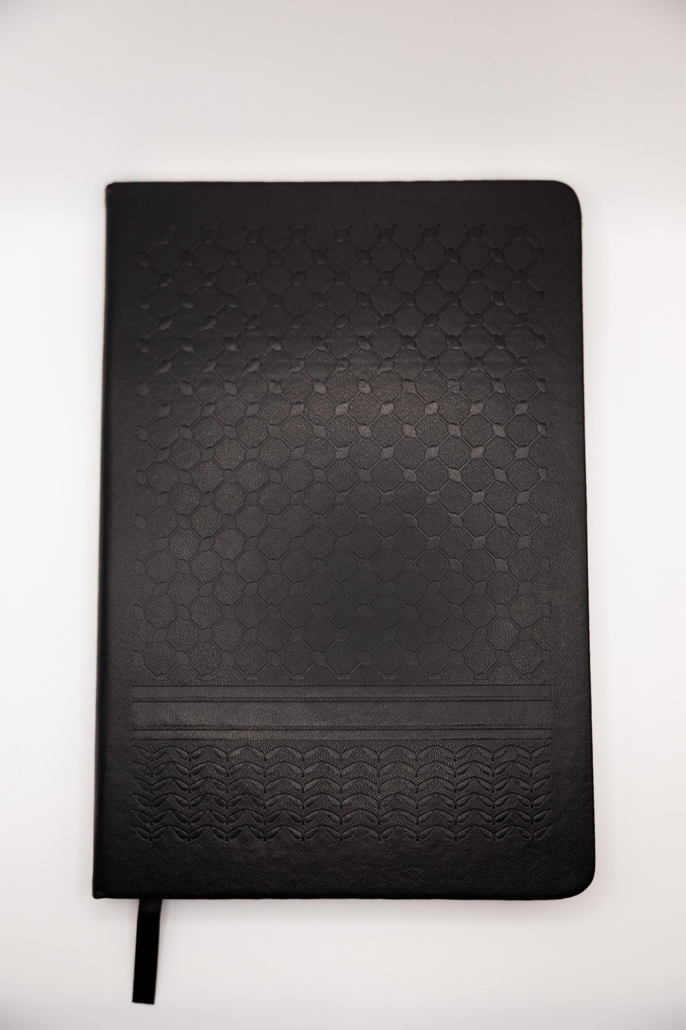 Black keffiyeh textured notebook on a white background