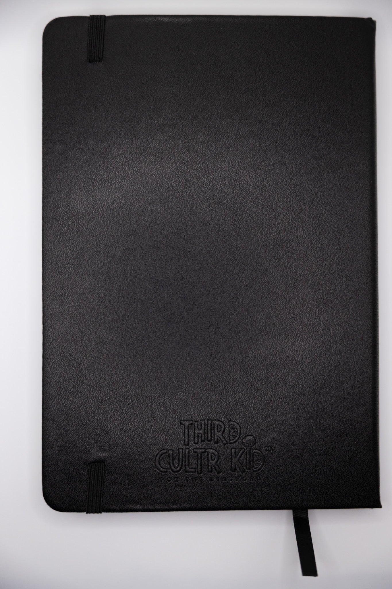 Black notebook with 'Third Cultur Kid' branding on a white background
