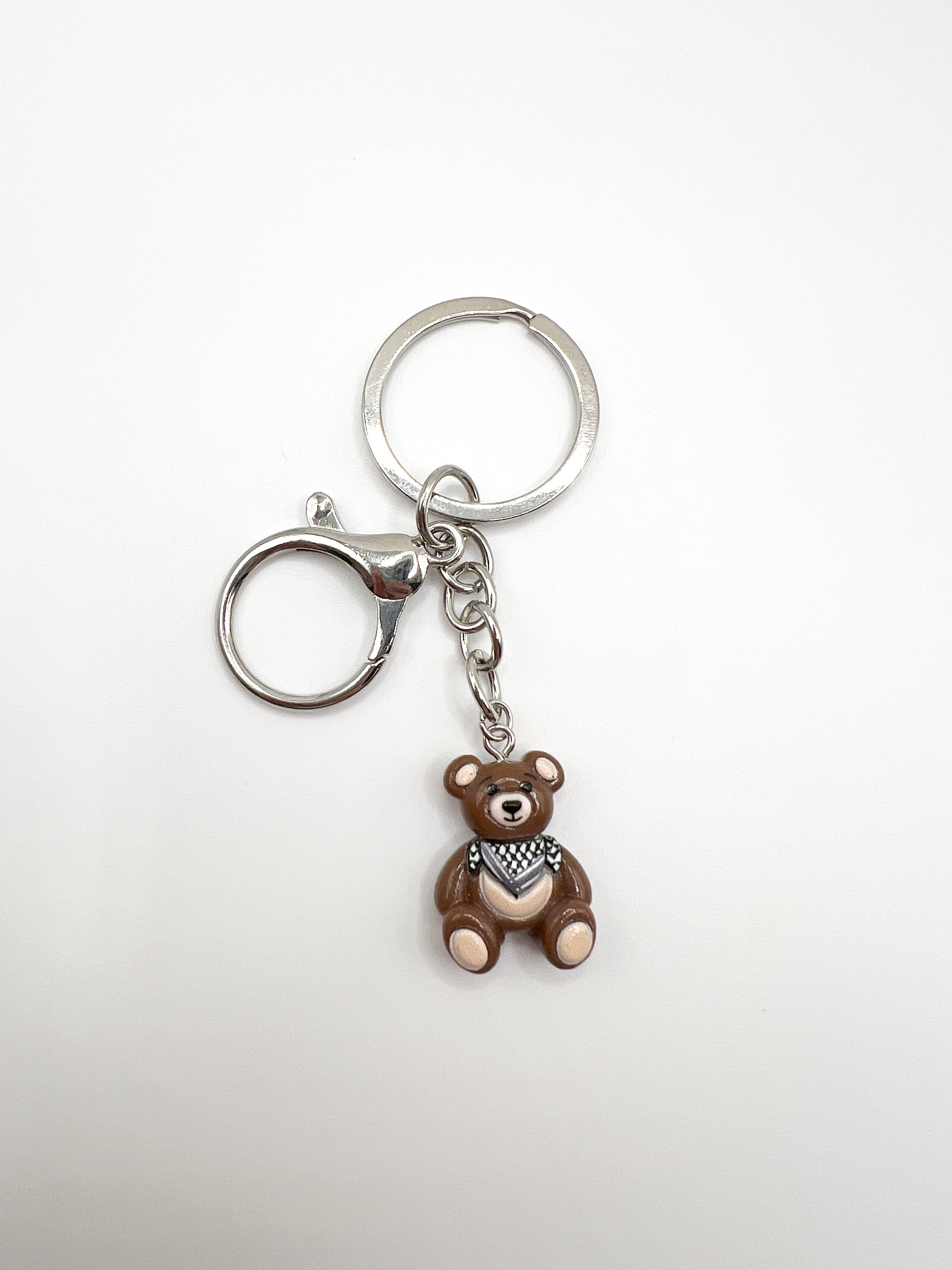 Keychain with a keffiyeh teddy bear charm on a white background