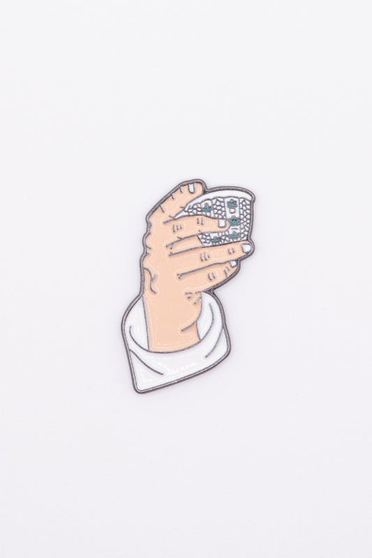 enamel sticker of a hand holding a finjan arabic coffee cup 
