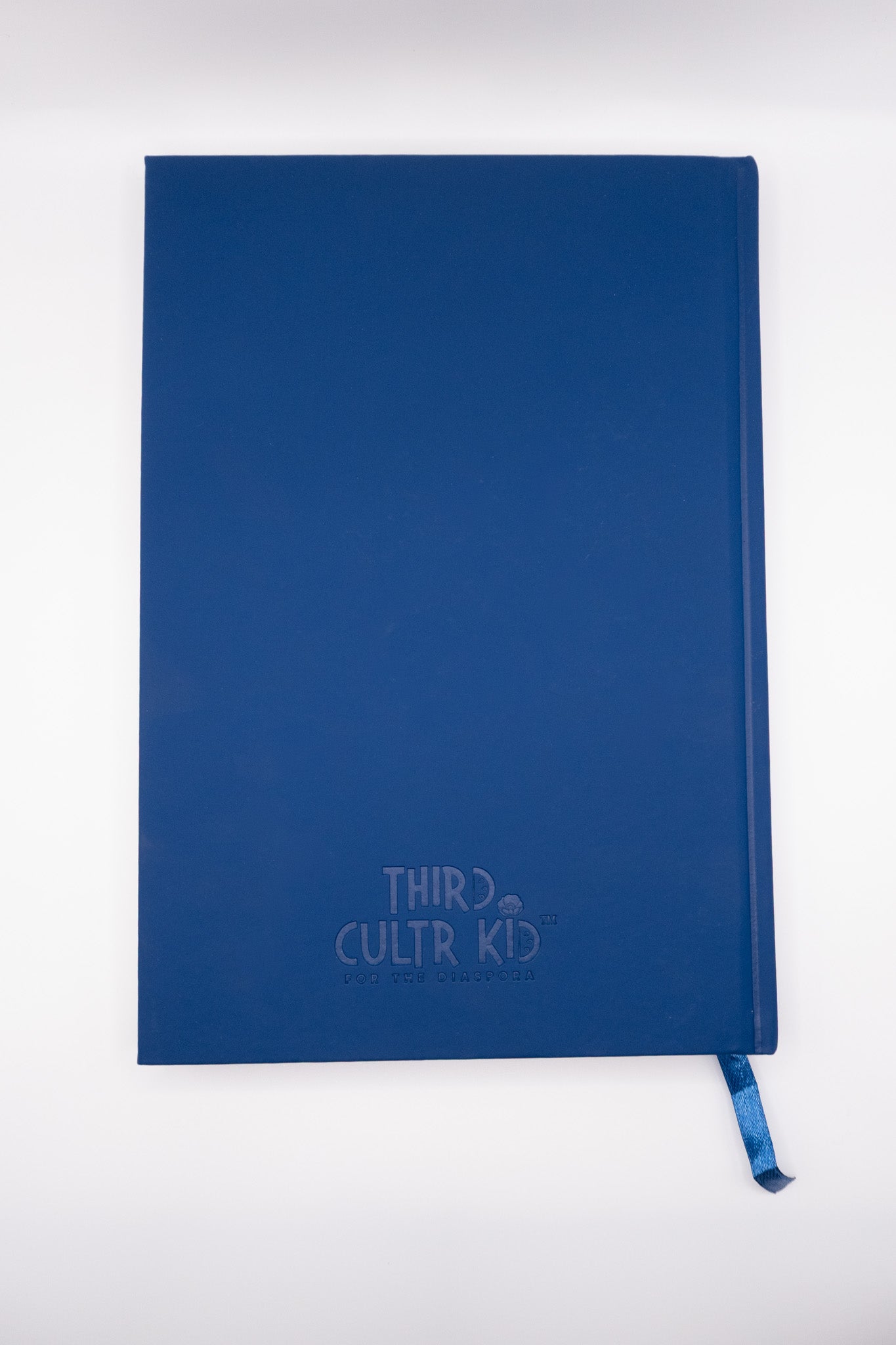 Blue notebook with 'Third Cultur Kid' branding on a white background