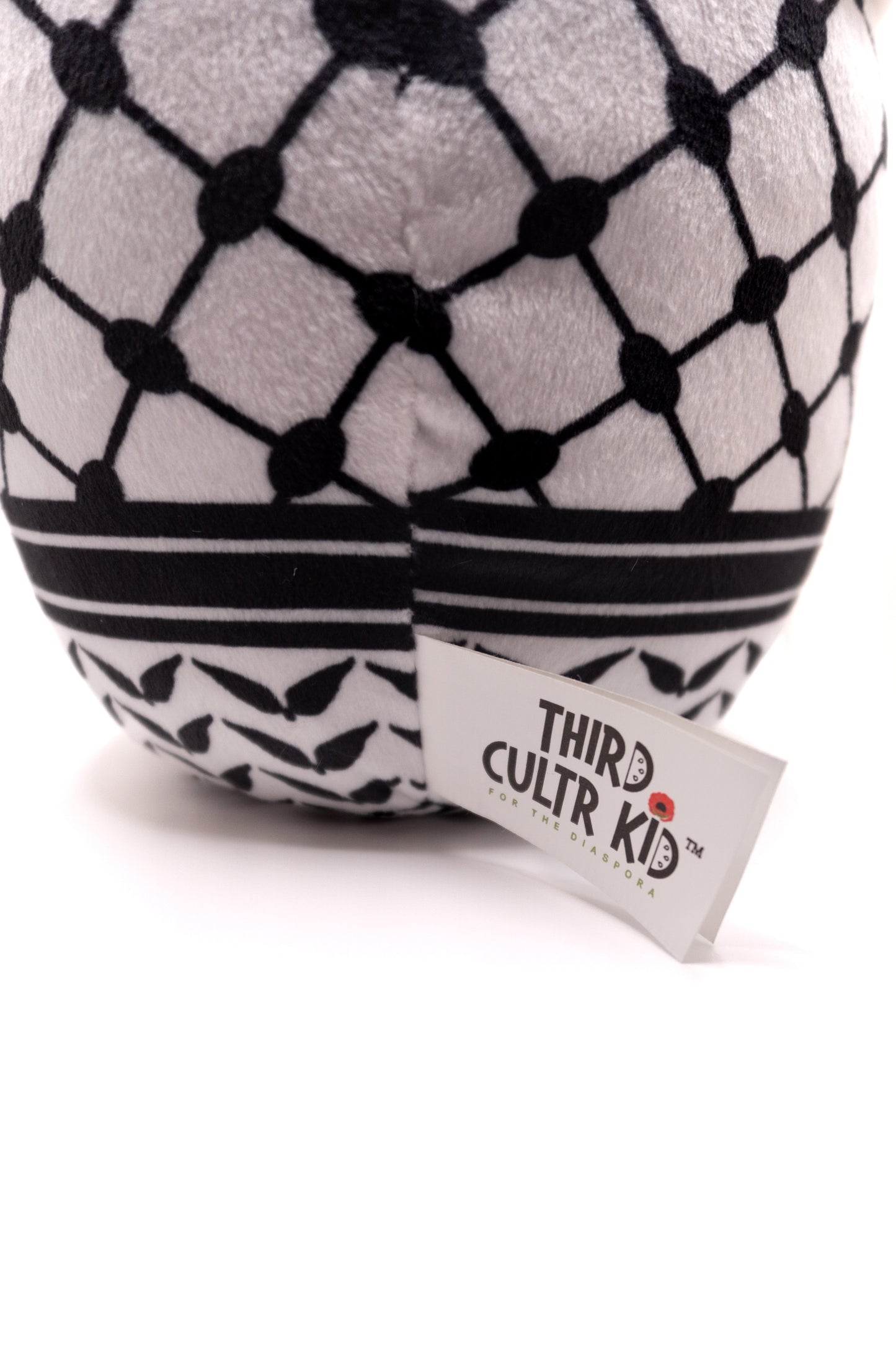 Plush toy Qahwa finjan with a face and keffiyeh pattern on a white background