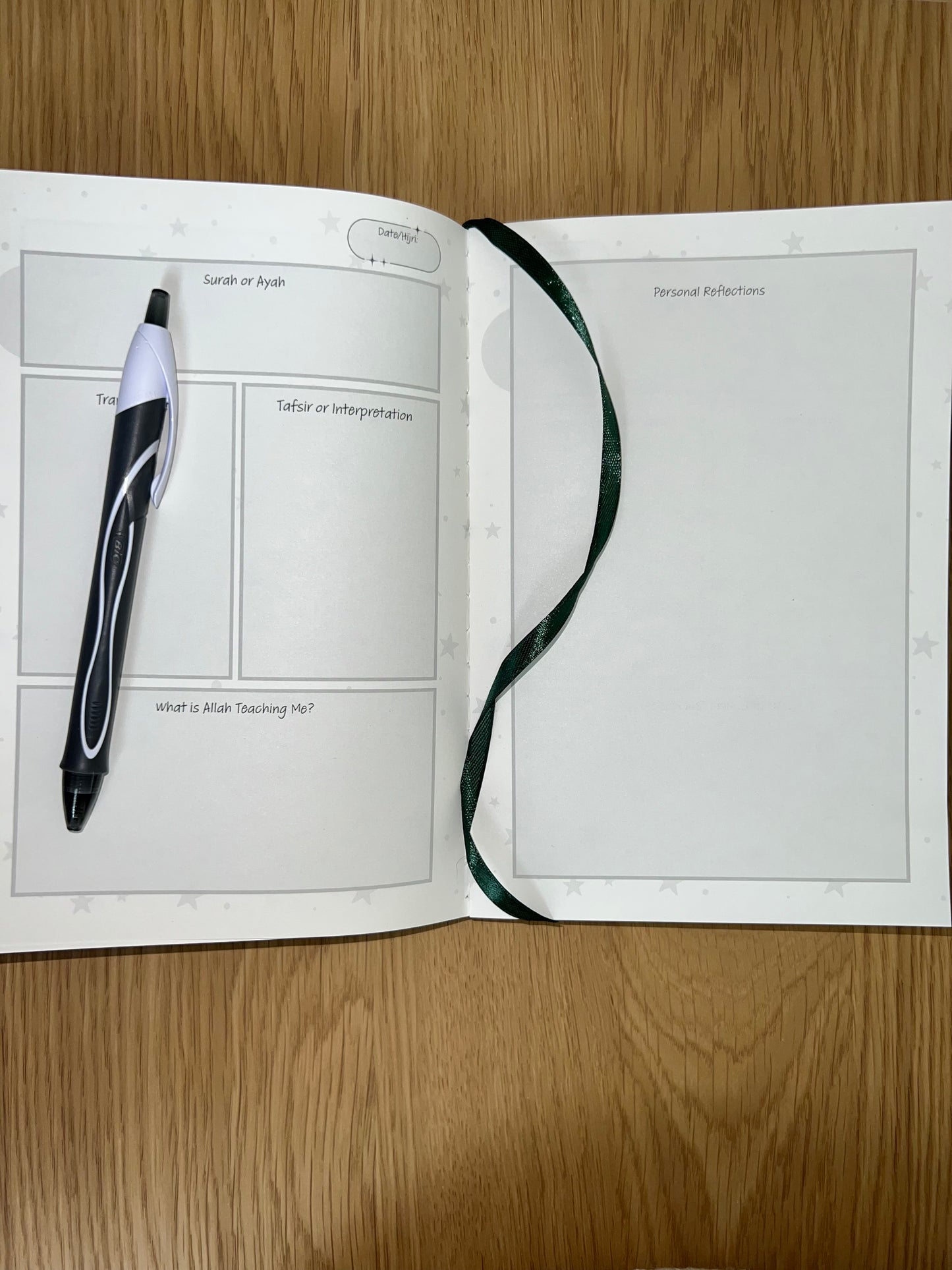 Open book with a pen on a wooden surface reflecting on Quran and ayah 