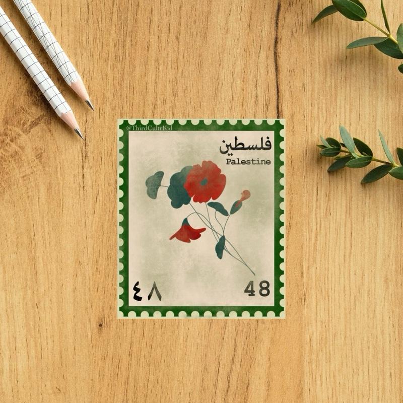 Vintage-style postage stamp with floral design on a wooden surface with pencils and leaves.
